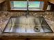 Close-up of a modern stainless steel sink with a gooseneck faucet and integrated rack at 3546 Mount Vernon Ct, Lawrenceville, GA 30044