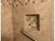 A neutral-toned tiled shower includes a safety bar and a niche shelf for added convenience at 3546 Mount Vernon Ct, Lawrenceville, GA 30044