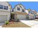 Lovely townhome with a two-car garage, featuring stone accents and a well-maintained front yard at 5123 Tulip Sq, Acworth, GA 30101