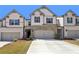 Charming townhome featuring a two-car garage, stone accents, and a well-maintained lawn, enhancing its curb appeal at 5123 Tulip Sq, Acworth, GA 30101