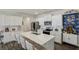 Modern kitchen with white cabinetry, stainless steel appliances, large island, and four bar stools at 5123 Tulip Sq, Acworth, GA 30101