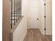 Hallway view featuring light wood-look floors and white doors with black hardware and a staircase at 560 Fisher Dr # 48, Alpharetta, GA 30009