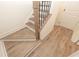 Staircase with light wood treads, black iron balusters, and light wood-look floors leading to a white door at 560 Fisher Dr # 48, Alpharetta, GA 30009