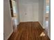 Hallway with hardwood floors leading to rooms with stone fireplace and natural light at 6419 Edenfield Dr, Lithonia, GA 30058