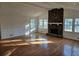 Living room with hardwood floors, a stone fireplace, and ample natural light at 6419 Edenfield Dr, Lithonia, GA 30058