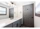 Bathroom featuring gray cabinetry, quartz countertop, large mirror, modern lighting, and a window at 1074 Peachtree Ne Walk # 115, Atlanta, GA 30309
