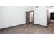 Empty room with laminate flooring, gray baseboards and trim, with an open door to the bathroom at 1074 Peachtree Ne Walk # 115, Atlanta, GA 30309