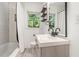 Bright bathroom with a modern vanity, subway tile shower, and a window overlooking the trees outside at 1424 Adele Sw Ave, Atlanta, GA 30314