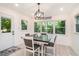 Bright dining area with a dark wood table, white chairs, and lots of natural light from the windows at 1424 Adele Sw Ave, Atlanta, GA 30314
