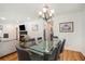 Elegant dining area with a glass table, modern chairs, and a view into the spacious living room at 1424 Adele Sw Ave, Atlanta, GA 30314