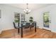 Modern dining room with a glass-top table, stylish chairs, and hardwood flooring at 1424 Adele Sw Ave, Atlanta, GA 30314