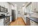 Spacious kitchen featuring stainless steel appliances, stone backsplash, white cabinetry, and hardwood floors at 2759 Arbor Se Ave, Atlanta, GA 30317