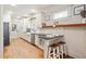 Open kitchen featuring white cabinetry, breakfast bar, and stainless steel appliances, illuminated by natural light at 2759 Arbor Se Ave, Atlanta, GA 30317