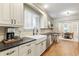 Bright kitchen with farmhouse sink, stainless steel appliances, stone backsplash, and breakfast bar leading to dining room at 2759 Arbor Se Ave, Atlanta, GA 30317