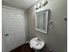 Simple bathroom featuring a white vanity, wood-look flooring, and updated lighting at 5183 Mccarter Ct, Stone Mountain, GA 30088