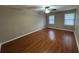 Large bedroom featuring hardwood floors, neutral paint, a ceiling fan, and two windows at 5183 Mccarter Ct, Stone Mountain, GA 30088