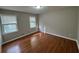A bright bedroom features hardwood floors, neutral paint, and two windows at 5183 Mccarter Ct, Stone Mountain, GA 30088
