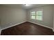 The bedroom has hardwood floors, neutral paint, and natural light from one window at 5183 Mccarter Ct, Stone Mountain, GA 30088