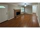 Cozy living room featuring a brick fireplace, hardwood flooring and a ceiling fan at 5183 Mccarter Ct, Stone Mountain, GA 30088