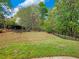 Expansive backyard featuring lush green grass, black fencing, and mature trees at 3544 Candytuft Run, Auburn, GA 30011