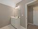 Bathroom vanity with sink, mirror, and three-light fixture; doorway leading to hallway at 3544 Candytuft Run, Auburn, GA 30011