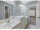 Bathroom with double sink vanity, mirror, three light fixture, and a view to the bedroom at 3544 Candytuft Run, Auburn, GA 30011