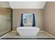 Bright bathroom featuring a modern freestanding tub, shower, and patterned tile flooring at 3544 Candytuft Run, Auburn, GA 30011