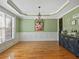 Formal dining room with hardwood floors, large window, accent wall, and decorative lighting fixture at 3544 Candytuft Run, Auburn, GA 30011