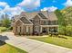 Charming two-story brick home with manicured lawn, mature trees, and a welcoming front porch at 3544 Candytuft Run, Auburn, GA 30011