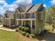 Beautiful two-story home showcasing brick and siding, complemented by lush landscaping and a charming front porch at 3544 Candytuft Run, Auburn, GA 30011