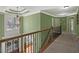 Upstairs hallway features carpet flooring and a decorative wrought iron railing overlooking the entry at 3544 Candytuft Run, Auburn, GA 30011
