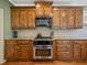 Kitchen features granite countertops, tiled backsplash, stainless appliances and dark hardwood flooring and cabinets at 3544 Candytuft Run, Auburn, GA 30011