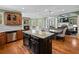 Kitchen overlooking living room with island, granite countertops, hardwood floors and a stone fireplace at 3544 Candytuft Run, Auburn, GA 30011