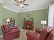 Cozy living room with fireplace, red chairs, lamp, and books at 3544 Candytuft Run, Auburn, GA 30011