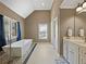 Main bathroom with freestanding tub, separate vanities, and elegant fixtures; tile flooring at 3544 Candytuft Run, Auburn, GA 30011