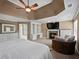 The primary bedroom includes a fireplace, a television, tray ceilings, and natural lighting at 3544 Candytuft Run, Auburn, GA 30011