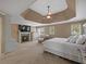 Spacious main bedroom suite features a cozy fireplace, and a tray ceiling with a ceiling fan at 3544 Candytuft Run, Auburn, GA 30011