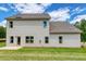Back exterior view of a two-story house with a patio and a spacious green lawn at 700 Relic Rdg, Hampton, GA 30228