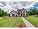 Beautiful, two-story home featuring a brick facade, manicured lawn, and inviting walkway at 700 Relic Rdg, Hampton, GA 30228