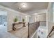 Upstairs hallway featuring a decorative table, wrought iron railing, and neutral paint at 700 Relic Rdg, Hampton, GA 30228