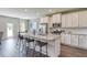 Open kitchen featuring a large island with bar seating, stainless appliances, and white cabinets at 700 Relic Rdg, Hampton, GA 30228