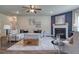 Inviting living room featuring a fireplace, ceiling fan, neutral colors, and an area rug at 700 Relic Rdg, Hampton, GA 30228