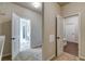 Walk-in closet with an open door to a bathroom featuring neutral colors and tile flooring at 700 Relic Rdg, Hampton, GA 30228