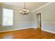 Elegant dining room with hardwood flooring, crown molding, and a stylish chandelier, ideal for hosting gatherings at 974 Regal Hills Ln, Mableton, GA 30126