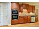 Elegant kitchen features custom wood cabinets and stainless steel appliances, creating a warm and inviting atmosphere at 974 Regal Hills Ln, Mableton, GA 30126