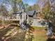 Exterior of home with multi-level decks, wooded landscape, siding, roof and stone retaining wall at 270 Boulder Dr, Roswell, GA 30075