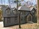 Gray home with prominent roof and dormers, complemented by a stone-accented entrance and mature trees at 270 Boulder Dr, Roswell, GA 30075