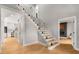 Bright foyer boasts hardwood floors, a glass-railed staircase, and views of kitchen and living space at 270 Boulder Dr, Roswell, GA 30075