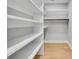 Large, open walk-in closet with white shelving and hardwood floors at 270 Boulder Dr, Roswell, GA 30075