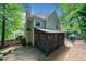 Back of home with stone and gravel landscaping, screened in porch, paver patio, and mature trees at 2009 Westside Ln, Woodstock, GA 30189